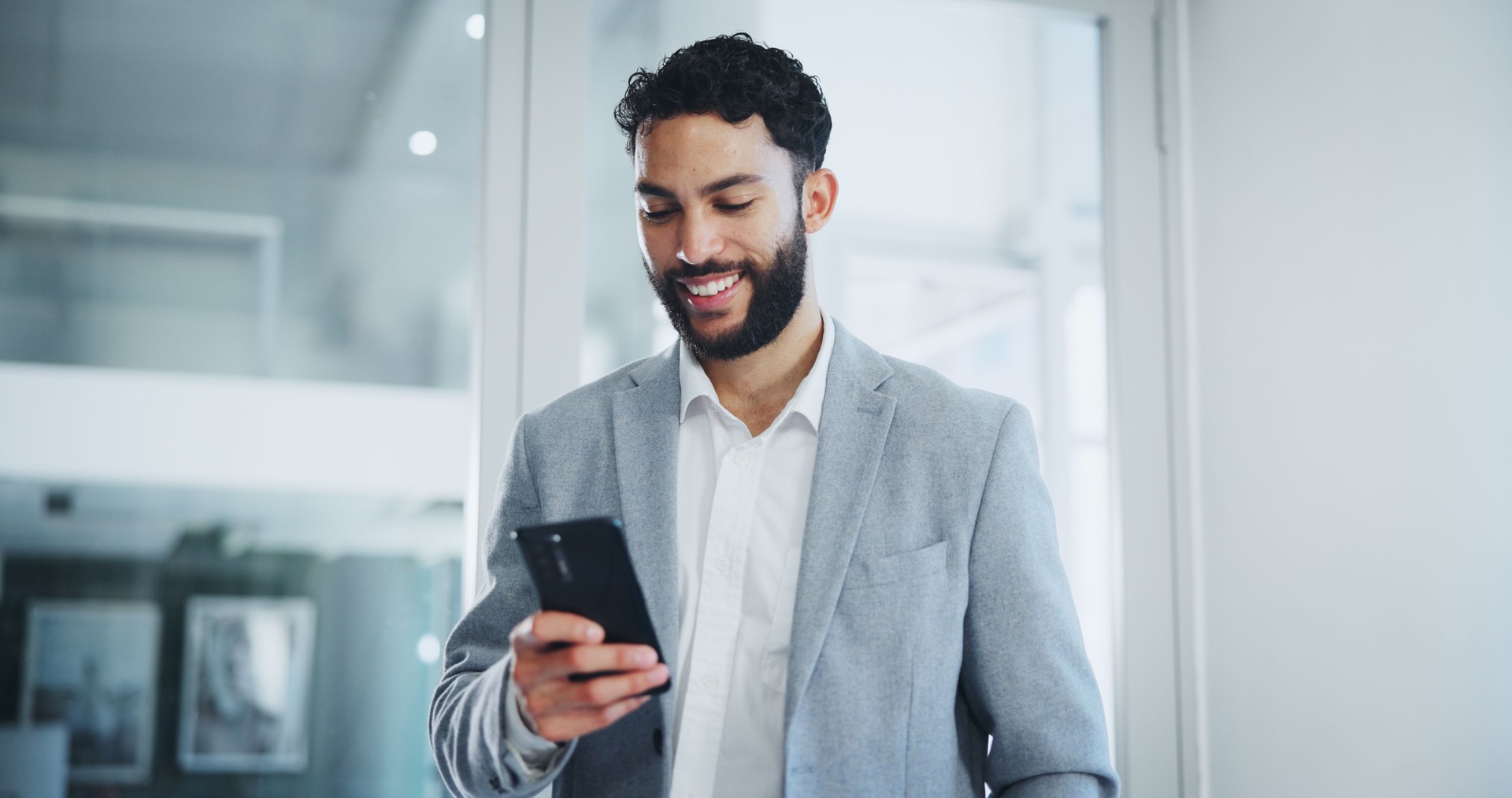 Comunicación, sonrisa y texto de hombre de negocios con teléfono inteligente en la oficina para redes, correo electrónico y discusión corporativa. Persona masculina, mensaje móvil o publicación en redes sociales de la empresa para proyecto y consulto
